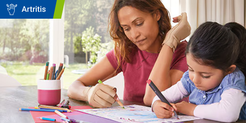 Madre e hija se sientan a la mesa y colorean un dibujo Madre e hija se sientan a la mesa y colorean un dibujo